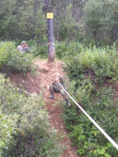 2003 Jeep TJ - A soldier rappels down a steep incline while another observes from a higher position, with a numbered post indicating a training station.