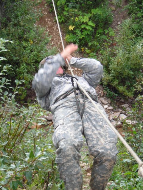 2003 Jeep TJ - A soldier uses a rope to descend a steep, vegetated incline during an outdoor training exercise.