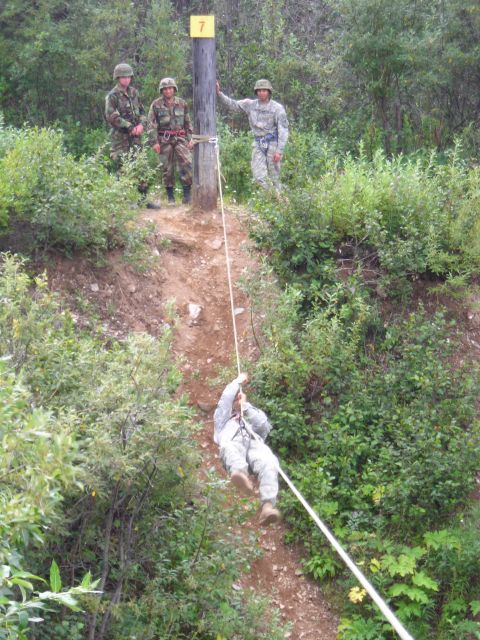 2003 Jeep TJ - Soldiers participate in a rappelling exercise down a steep, wooded incline.