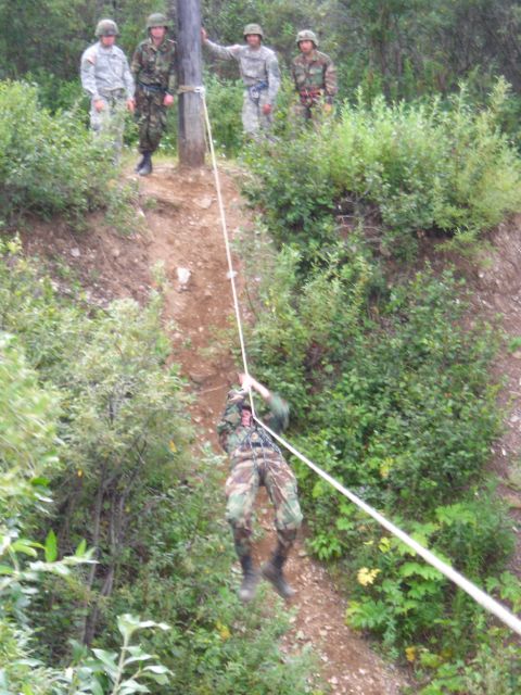 2003 Jeep TJ - Military personnel practice rappelling down a steep, vegetated slope.