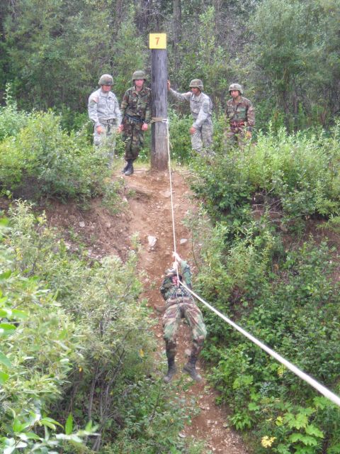 2003 Jeep TJ - Military personnel participate in a rappelling training exercise in a wooded area.