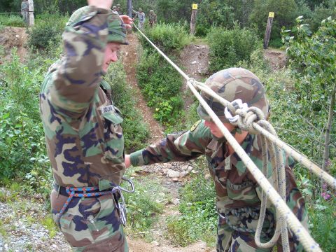 2003 Jeep TJ - Two soldiers are engaged in a rope training exercise in an outdoor environment.