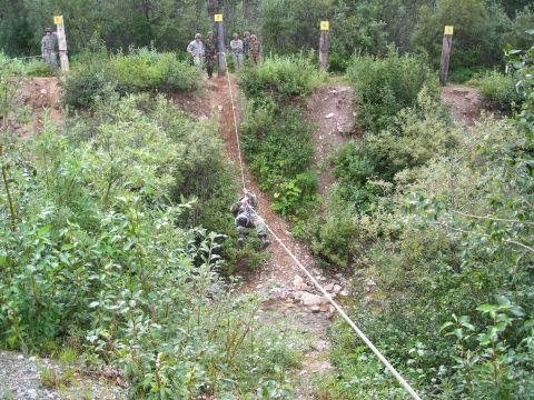 2003 Jeep TJ - Military personnel participate in a rappelling training exercise on a steep, wooded slope.