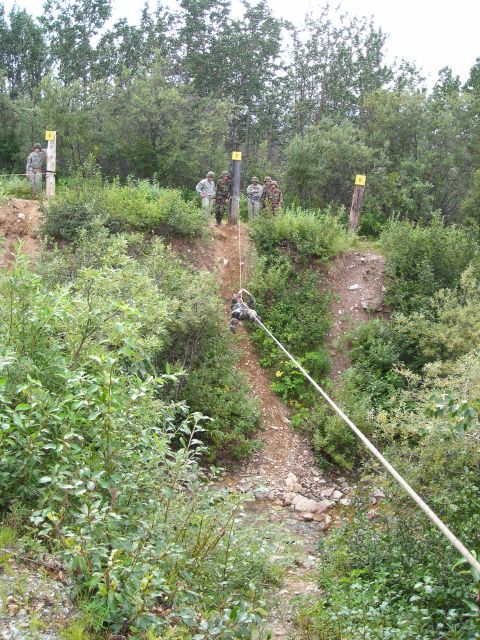 2003 Jeep TJ - Soldiers participate in a training exercise involving rappelling down a steep, vegetated incline.