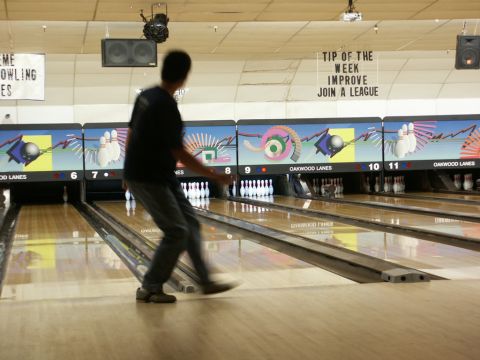 2001 Mercury Grand Marquis - A person bowls in a bowling alley, with lane numbers and graphics visible on the back wall.