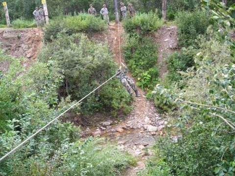 2003 Jeep TJ - A soldier participates in a rappelling exercise, with others watching from the top of the slope.