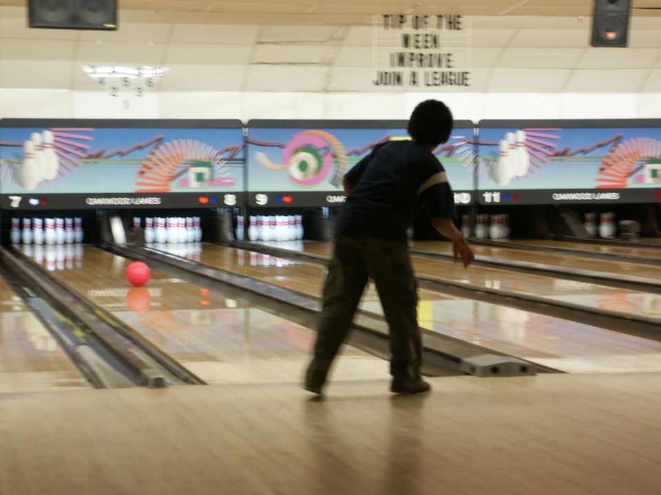 Bowling alley with lanes, pins, and a person bowling