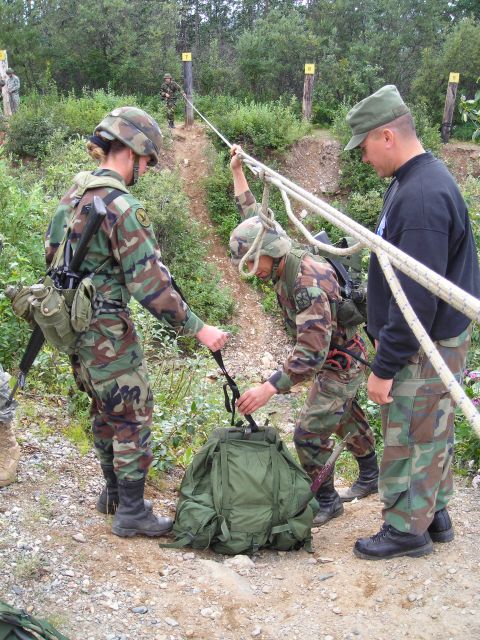 2003 Jeep TJ - Personnel are seen handling ropes and a large green backpack during what appears to be a training exercise.
