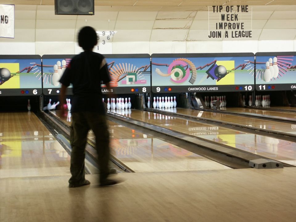 Bowling alley with lanes, pins, and a person bowling