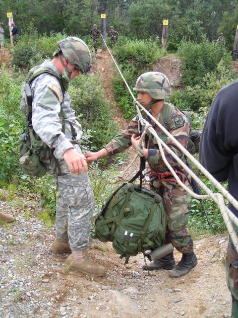 2003 Jeep TJ - Military personnel are seen during a training exercise involving ropes and backpacks on an inclined terrain.