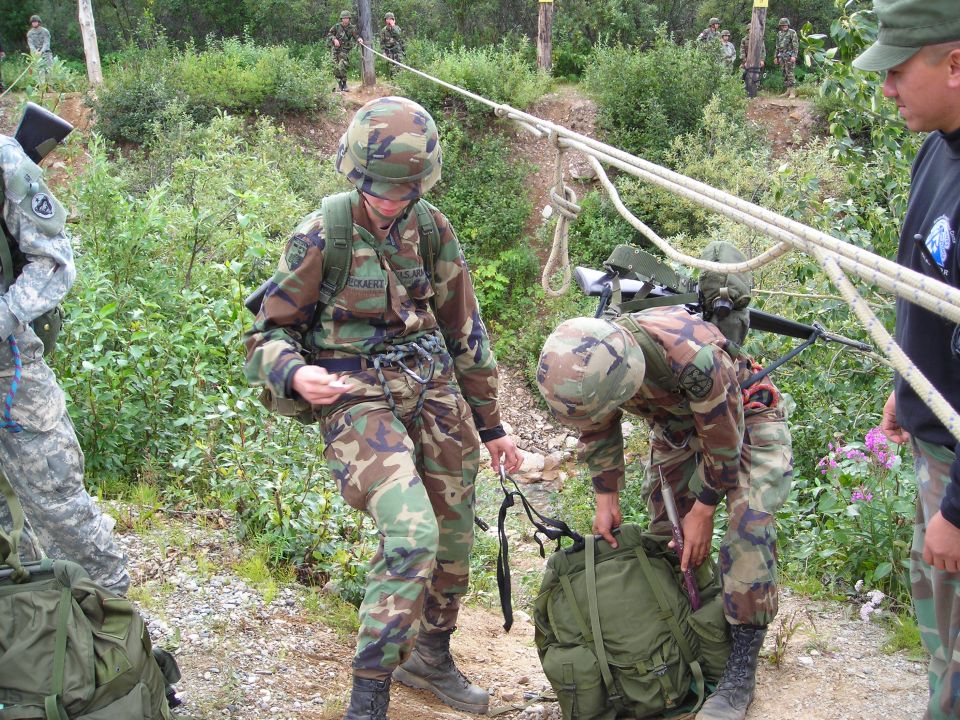 soldiers in camouflage gear preparing for rappelling with ropes and backpacks