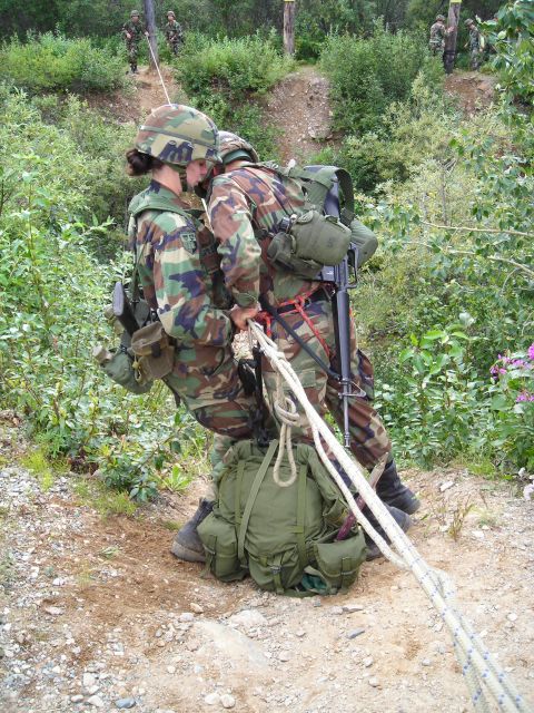 2003 Jeep TJ - Military personnel practice rappelling techniques on a wooded hillside, utilizing ropes and safety equipment.
