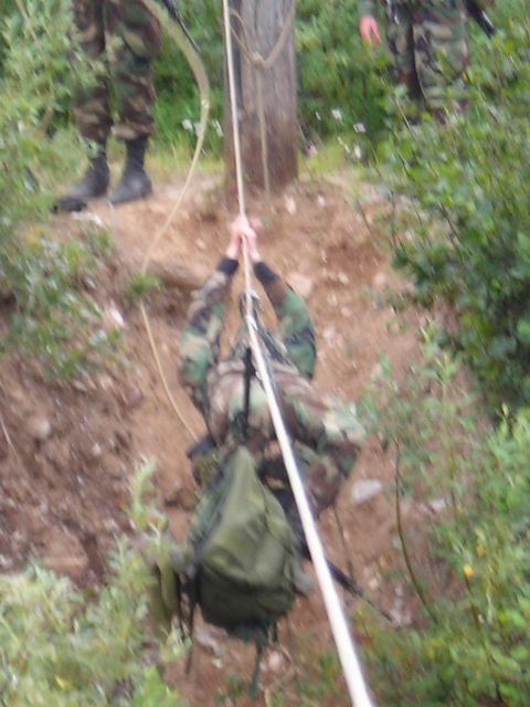 2003 Jeep TJ - Soldiers in camouflage descend a steep, wooded incline using a rope during a training exercise.