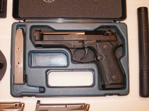 1998 Ford Crown Victoria - A handgun, spare magazine, and suppressor are neatly arranged in a protective carrying case.