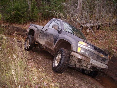 2000 Chevrolet Tahoe - Chevrolet Colorado pickup truck navigating a muddy off-road trail.