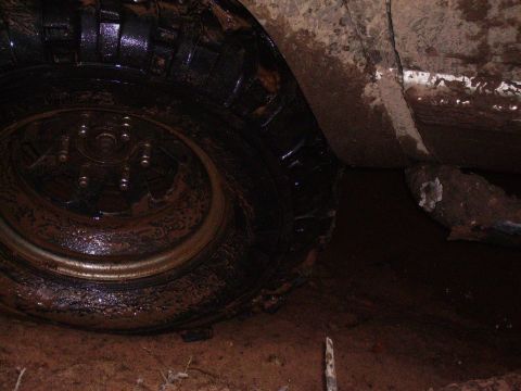 2000 Chevrolet Tahoe - A vehicle's tire and fender are caked in mud, suggesting it has been driven through difficult terrain.
