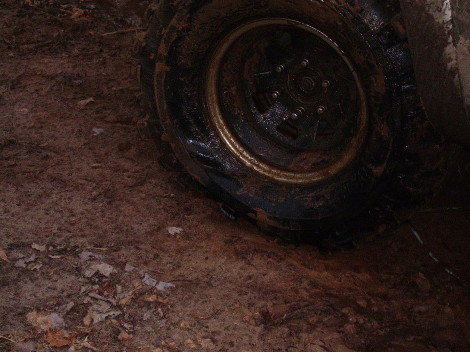 Muddy tire and wheel stuck in dirt