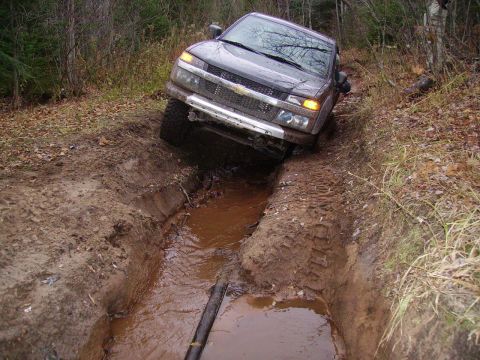 2000 Chevrolet Tahoe - Truck is stuck in a muddy rut during off-road driving.