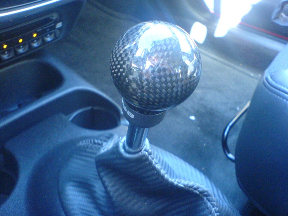 Carbon fiber shift knob on a metal stick with a matching shift boot