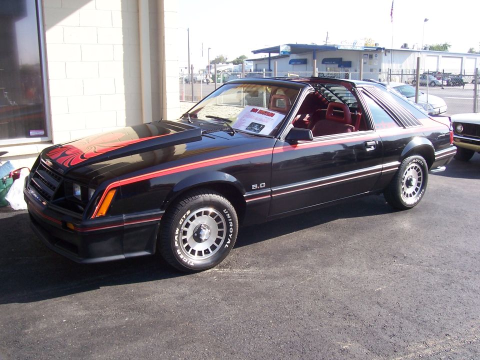 Black Fox-body Mustang 5.0 hatchback with red stripes and red interior, T-tops out