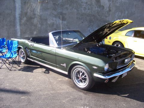 2002 Ford Mustang - Green 1965 Ford Mustang convertible parked outdoors with hood open, another car visible behind it.