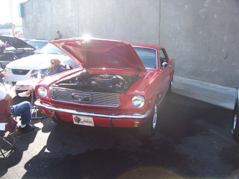 2002 Ford Mustang - A classic red Mustang is displayed with its hood open, parked beside a newer model.