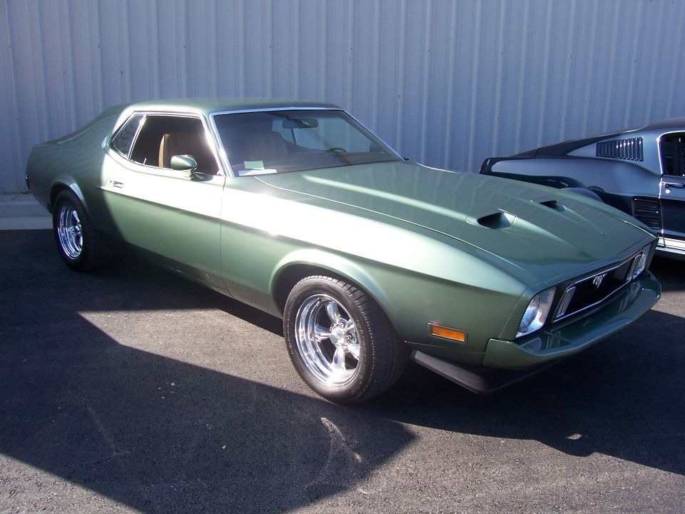 Green 1971 Ford Mustang coupe with hood scoops and chrome wheels