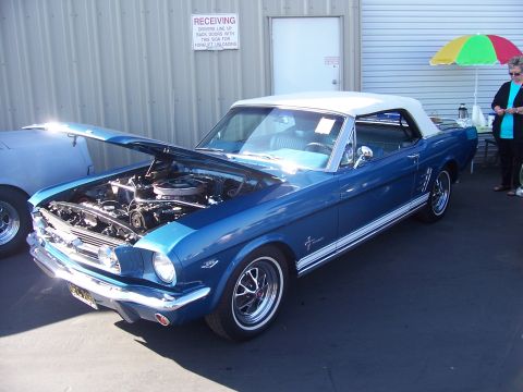 2002 Ford Mustang - A blue 1965 Ford Mustang convertible is displayed with its hood open, revealing the engine bay.