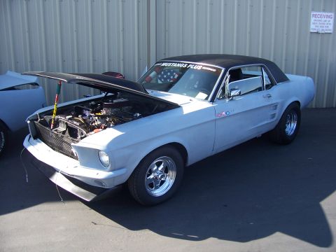 2002 Ford Mustang - This 1967 Ford Mustang coupe is being displayed with its hood open, revealing the engine bay.