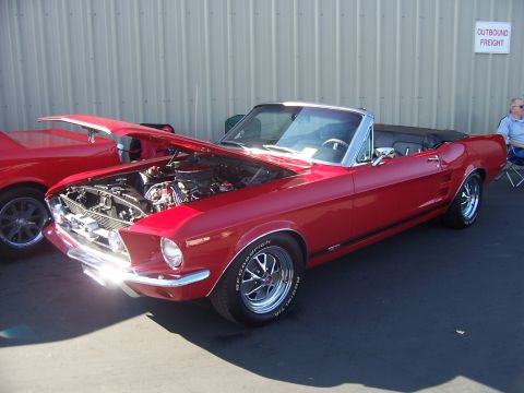 2002 Ford Mustang - A red 1967 Ford Mustang convertible is displayed with its hood open, revealing the engine compartment.