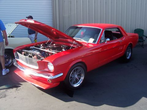 2002 Ford Mustang - A red 1965 Ford Mustang coupe is displayed with its hood open, revealing the engine bay.