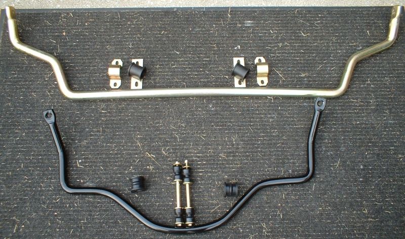 Gold front and black rear sway bars with bushings, brackets, and end links laid out on dark carpet