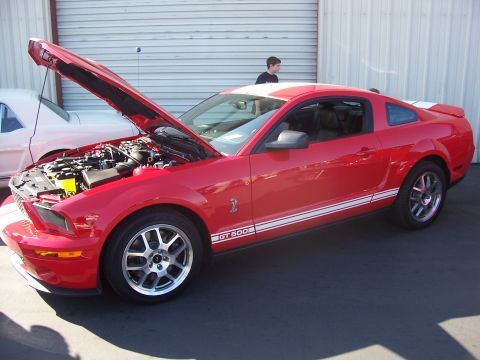 2002 Ford Mustang - A red 2007 Ford Mustang GT 500 is displayed with its hood open, revealing the engine compartment.