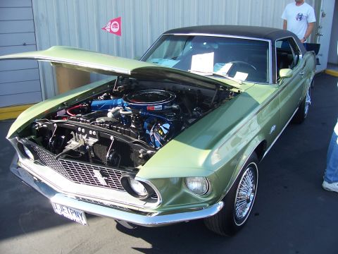 2002 Ford Mustang - A classic green 1969 Ford Mustang coupe is displayed with its hood open, revealing the engine bay.