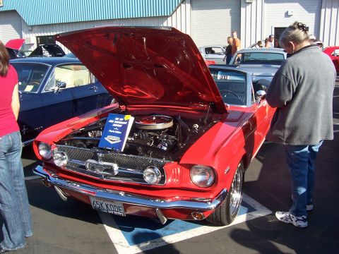 2002 Ford Mustang - A red classic Ford Mustang convertible is displayed with its hood open, revealing the engine bay.