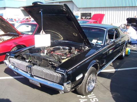 2002 Ford Mustang - This black 1969 Mercury Cougar is displayed with its hood open, revealing the engine bay.