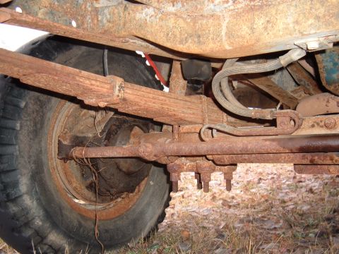 1979 Ford Bronco - Undercarriage view showing a heavily rusted leaf spring and axle assembly.