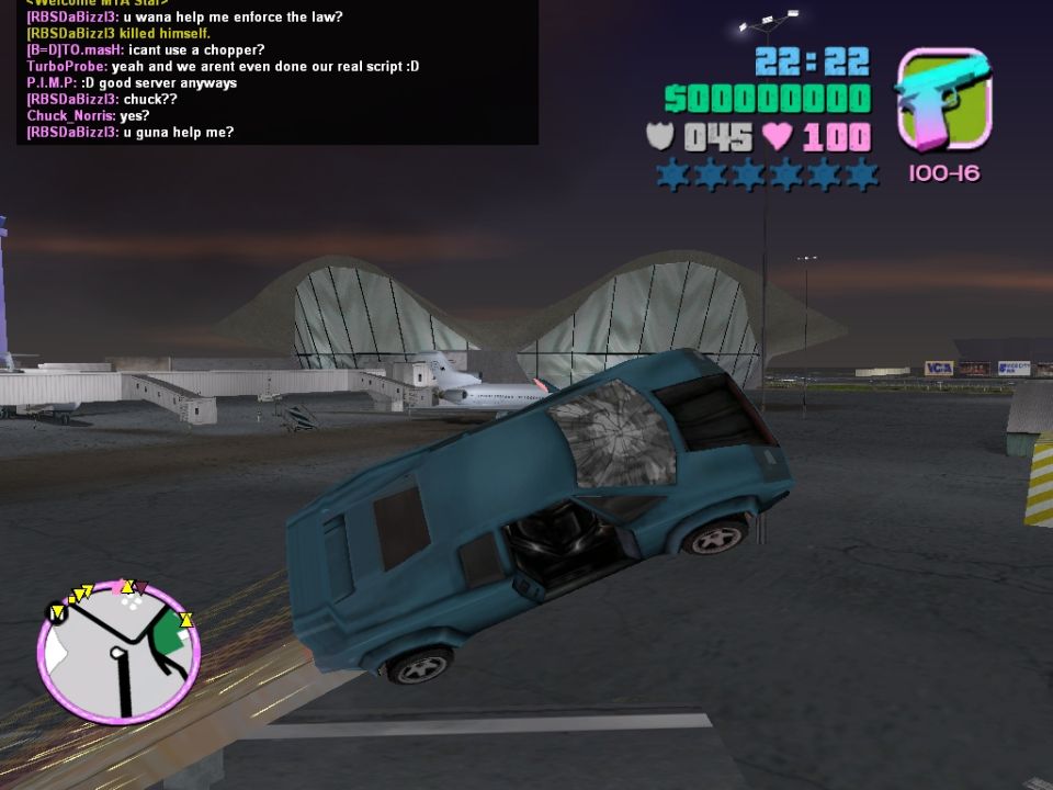 Video game scene with a blue car tilted on its side. Game interface elements and chat log are visible