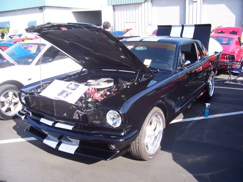 2002 Ford Mustang - A classic black Ford Mustang is displayed with its hood open, revealing the engine bay.
