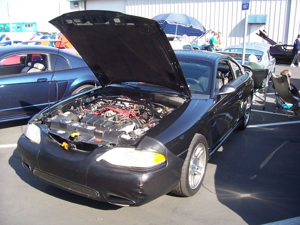 Black 2002 Ford Mustang front view with hood open, showing engine