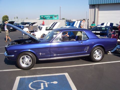 2002 Ford Mustang - A blue classic Ford Mustang is parked at a car show with its hood open.