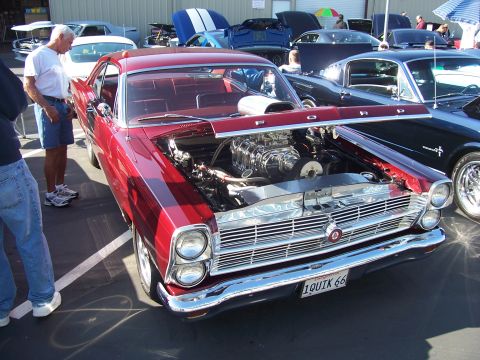 2002 Ford Mustang - A custom 1966 Ford Fairlane, a prominent supercharger under its hood, is displayed at an outdoor car show.