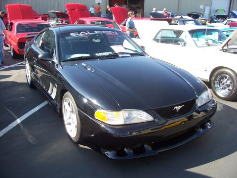 2002 Ford Mustang - A black Saleen Mustang is displayed at an outdoor event with other vehicles around it.