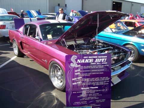 2002 Ford Mustang - A custom 1965 Mustang Fastback is displayed with its hood open at an outdoor event.
