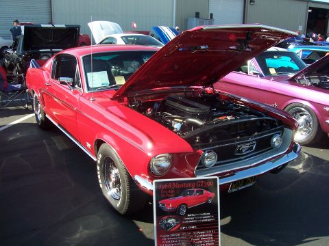 2002 Ford Mustang - A red 1968 Ford Mustang GT390 is displayed with its hood open, revealing the engine bay.