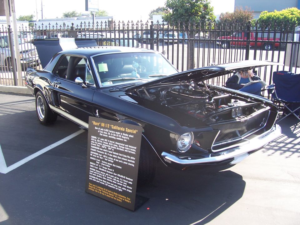 Black 1968 Ford Mustang California Special with hood open and display sign