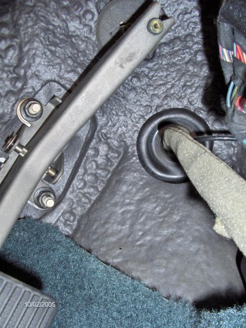 1996 Mercury Grand Marquis - The grommet where the shifter cable needs to be rerouted through. It is above and to the right of the accel pedal. THe lines you see runnin…