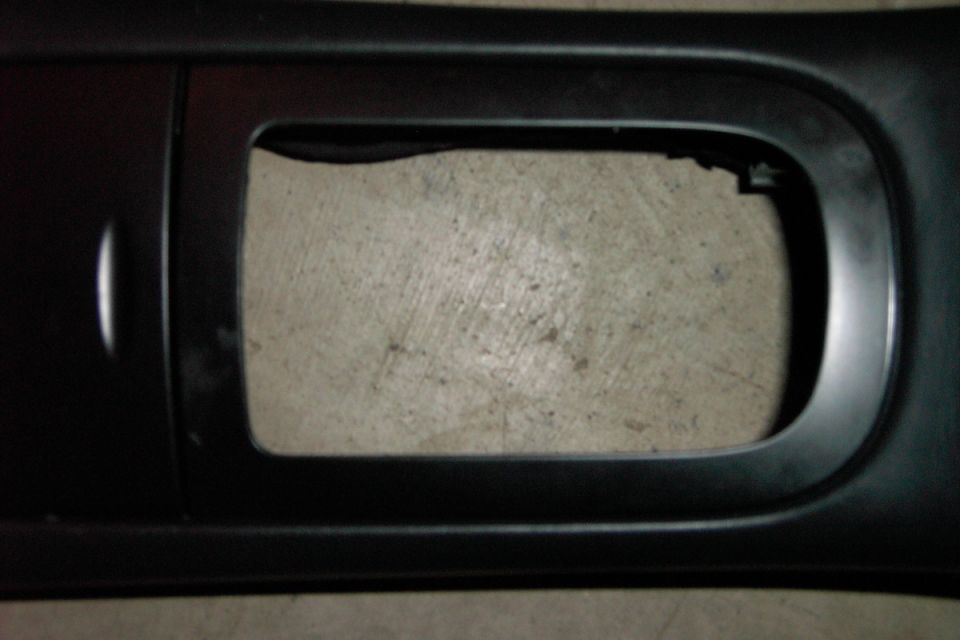 The shifter bezel surround.

Notice the damage.

I refnished it prior to install with a lightly textured black paint for a factory look