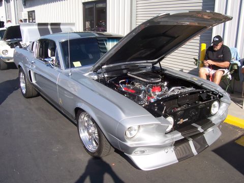 2002 Ford Mustang - A classic Mustang fastback with its hood open is displayed outdoors, with another vehicle partially visible behind it.