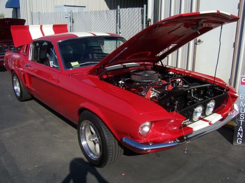 2002 Ford Mustang - A red 1967 Ford Mustang fastback is displayed with its hood open, revealing the engine bay.
